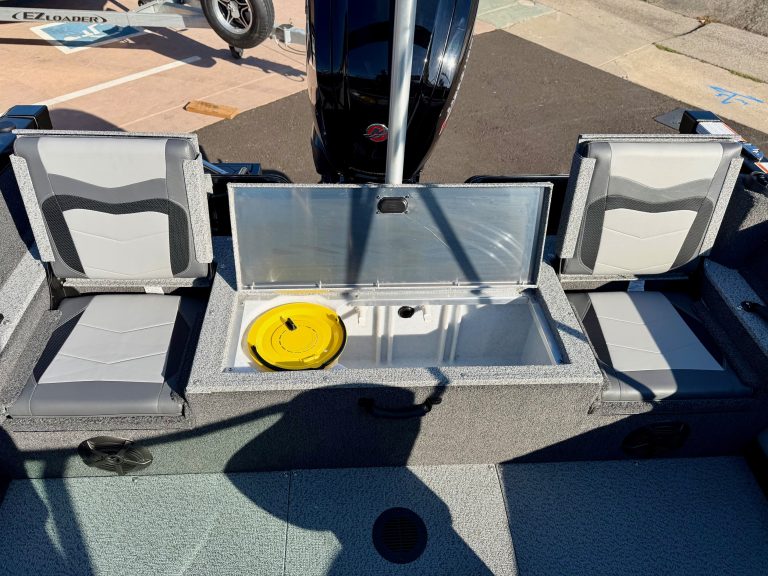 Boat storage compartment with seating and outboard motor in the background.