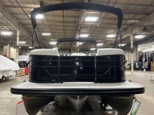 Boat with black and white exterior in indoor showroom.