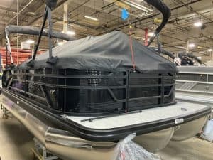 Modern pontoon boat with protective cover, ideal for leisure and fishing.