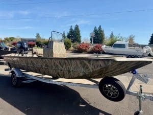 ALUMINUM FISHING BOAT WITH CAMO DESIGN AND TRAILER.