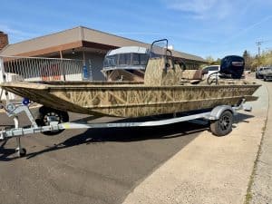 Crestliner fishing boat with outboard motor on trailer, ready for water.
