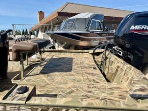 Durable boat on a camo-patterned trailer with powerful Mercury engine, ideal for fishing and leisure.
