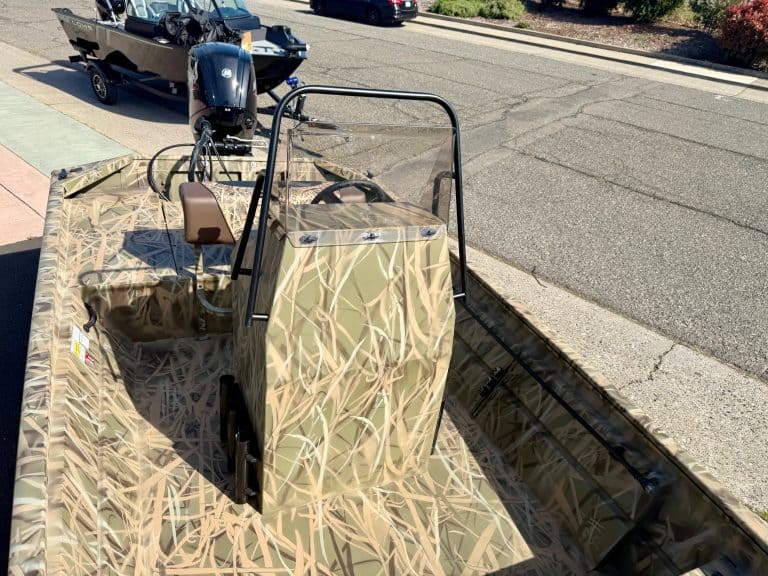 Boat with camouflage design, ideal for outdoor fishing and hunting adventures.