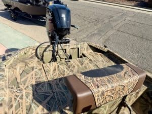 Boat with camouflage design and Mercury outboard motor, ideal for fishing and outdoor adventures.