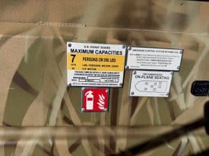 Marine safety and capacity labels on boat, including US Coast Guard max capacity and fire extinguish.