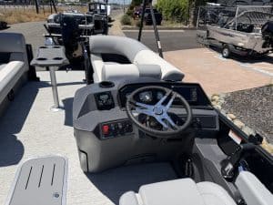 Helm console of a pontoon boat featuring advanced controls, steering wheel, and comfortable seating.