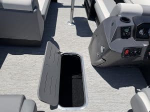 Boat dashboard with open storage compartment and electronic controls.