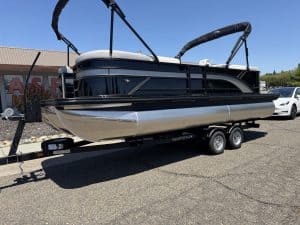 Yacht on trailer ready for transport at ASFB Marine, showcasing a sleek black and silver pontoon boa.