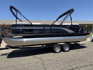 Sun Tracker pontoon boat with dual Bimini tops on trailer, ideal for leisure and water sports. Perfe.