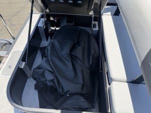 Boat storage compartment with cover on a modern boat for secure gear storage.