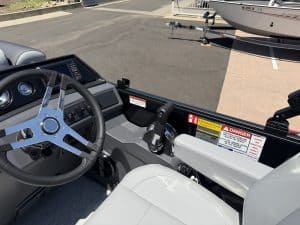 Boat cockpit with steering wheel, throttle, and control panel for marine navigation and operation.