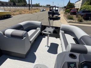 Pontoon boat with comfortable seating and a central table for relaxing on the water.