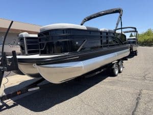 Black pontoon boat with sleek design on trailer, perfect for water adventures.