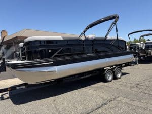 Modern pontoon boat on trailer, ideal for leisure and water activities.