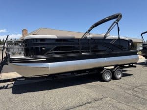 Pontoon boat with sleek black and silver design on a trailer.