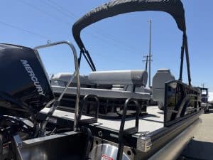 Pontoon boat with Mercury outboard motor, ideal for leisure and fishing, featuring a spacious deck a.
