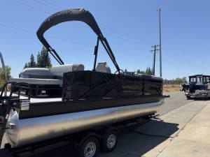 Modern black pontoon boat with silver accents, perfect for leisure and water adventures.