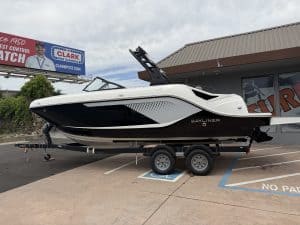 Bayliner boat on trailer in dealership lot, ready for water adventures.