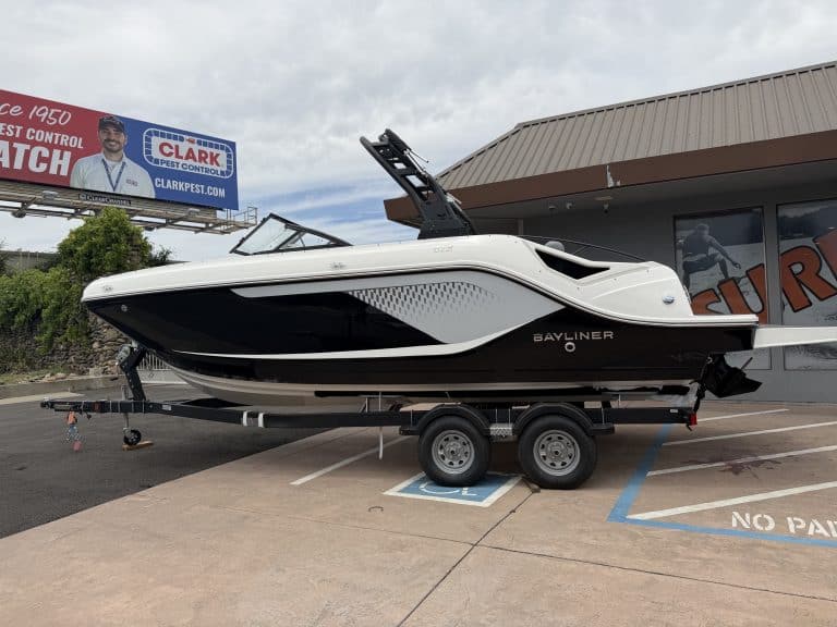 Bayliner boat on trailer in dealership lot, ready for water adventures.