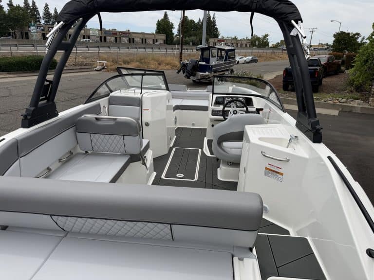 Recreational boat interior featuring steering console, seating, and canopy for outdoor adventures.