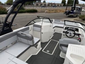 Modern boat interior with seating, steering wheel, and control panel for marine navigation.