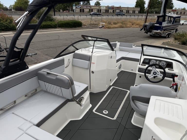 Modern boat interior with seating, steering wheel, and control panel for marine navigation.