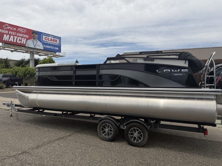 Modern pontoon boat on trailer, ideal for leisure and water activities.