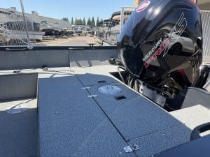 Boat deck with Mercury outboard engine at dealership lot.