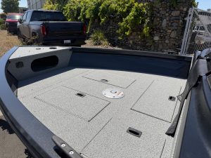 Close-up of boat deck with storage hatches and non-slip surface.