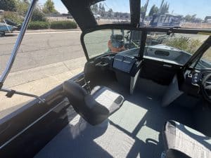 View of boat's cockpit with steering and control panel.