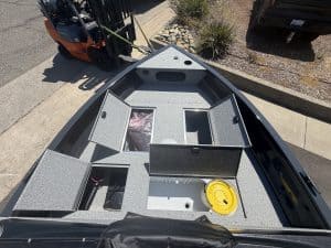 Boat interior with storage compartments and fishing gear.
