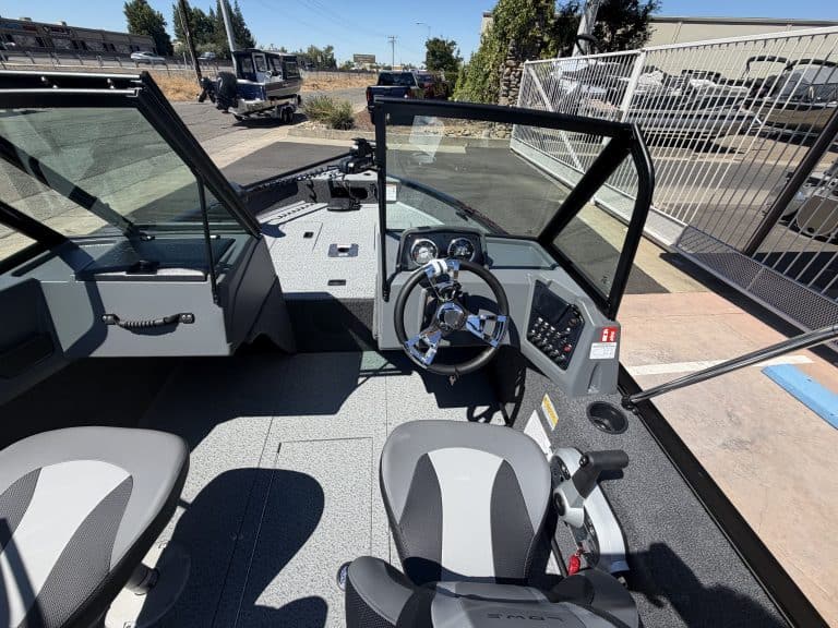 Boat cockpit with steering wheel and controls, new website branding.