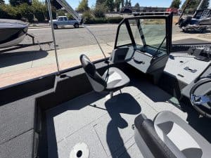 Boat cabin interior with steering console and seating area.