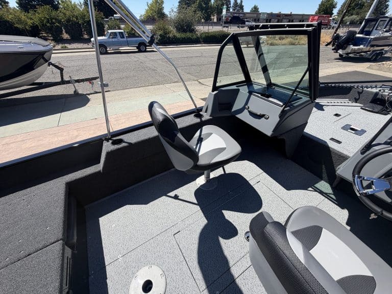 Boat cabin interior with steering console and seating area.