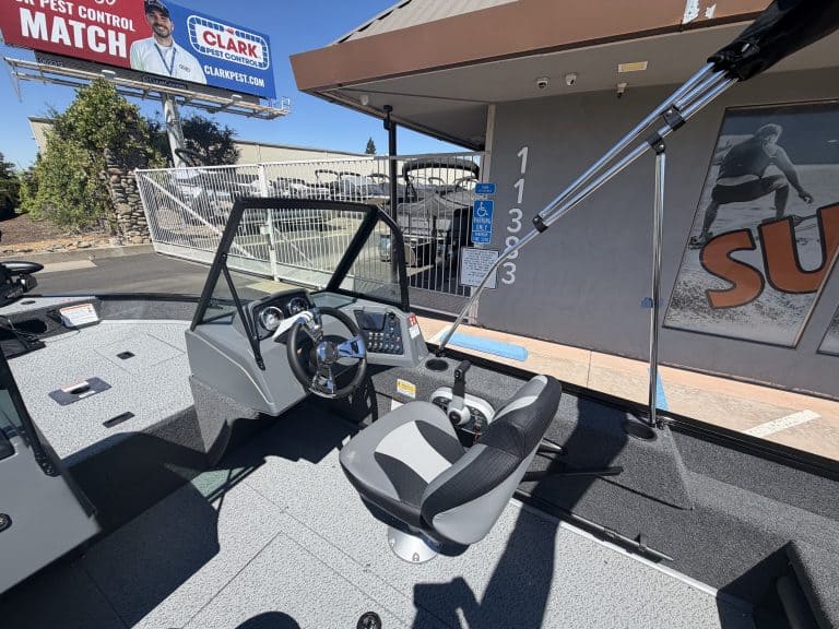 Boat steering console with steering wheel and controls for marine vessel.