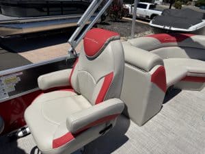Boat seats with red and gray upholstery on a pontoon boat.