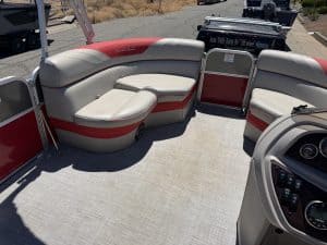 Pontoon boat interior with cushioned seating and steering console.