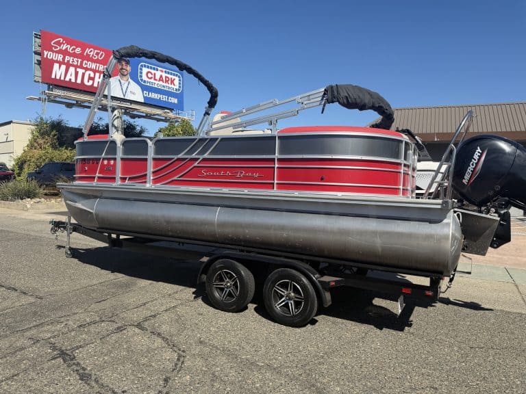 Red and black South Bay pontoon boat with Mercury outboard motor on trailer.