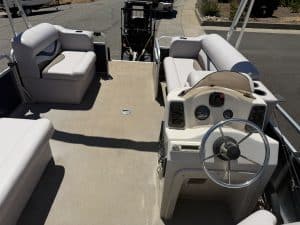 Pontoon boat interior with comfortable seating and steering wheel for leisure boating.