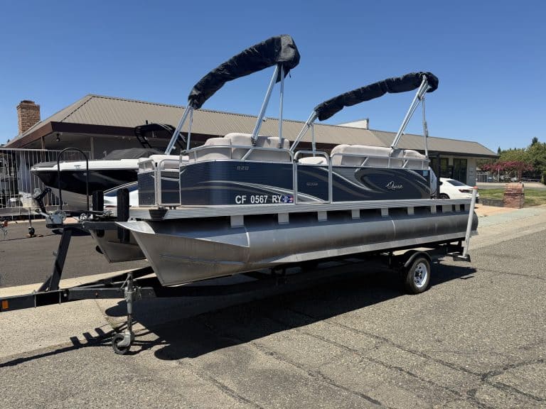 Pontoon boat on trailer with canopy, ready for transport or display.