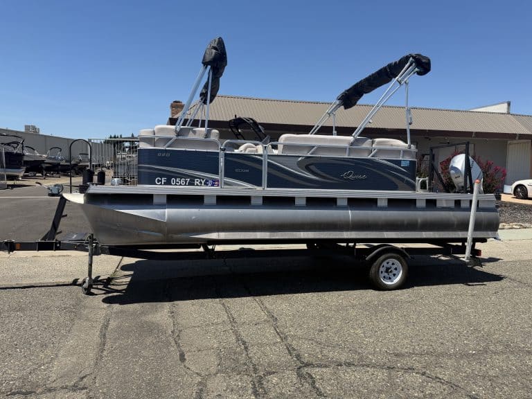 Pontoon boat on trailer at ASFB Marine with clear blue sky.