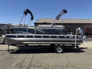 Pontoon boat on trailer with canopy and boat accessories.