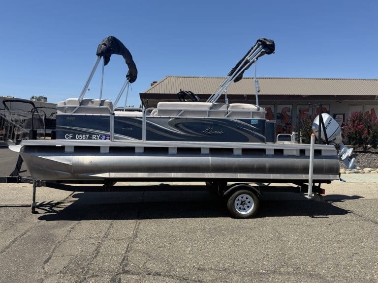 Pontoon boat on trailer with canopy and boat accessories.