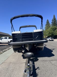Bennington 22FT SwingBack pontoon boat on trailer in parking lot.