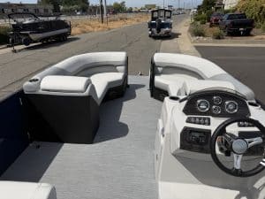 View of the interior of a Lowe SS 230 WV pontoon boat with seating and steering wheel.
