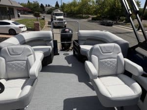 Luxury boat interior with white seating and view of the water.