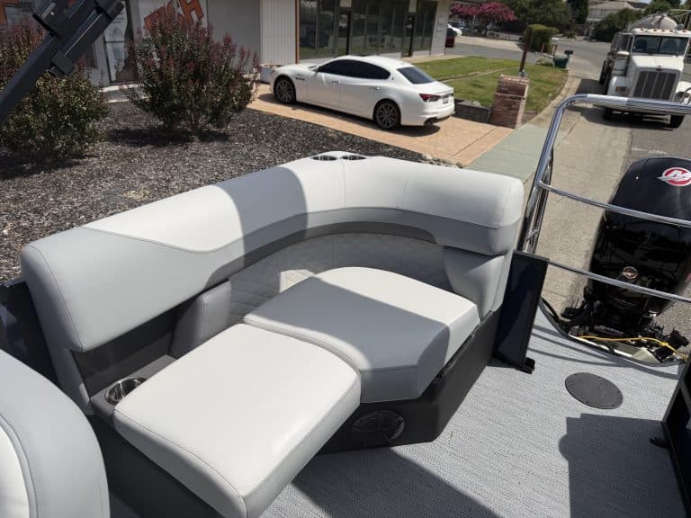 Comfortable boat seating area with white cushions on a pontoon boat.