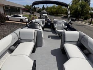 Luxury boat interior with white seating and steering console.