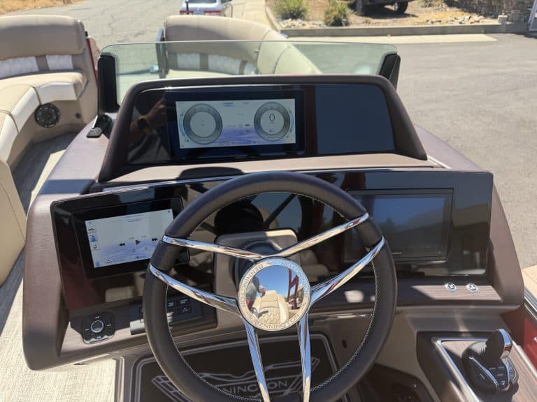 Boat dashboard with digital gauges and steering wheel for Bennington 25FT Q.