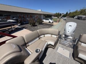 Luxury pontoon boat with beige seating and outboard motor at ASFB Marine.